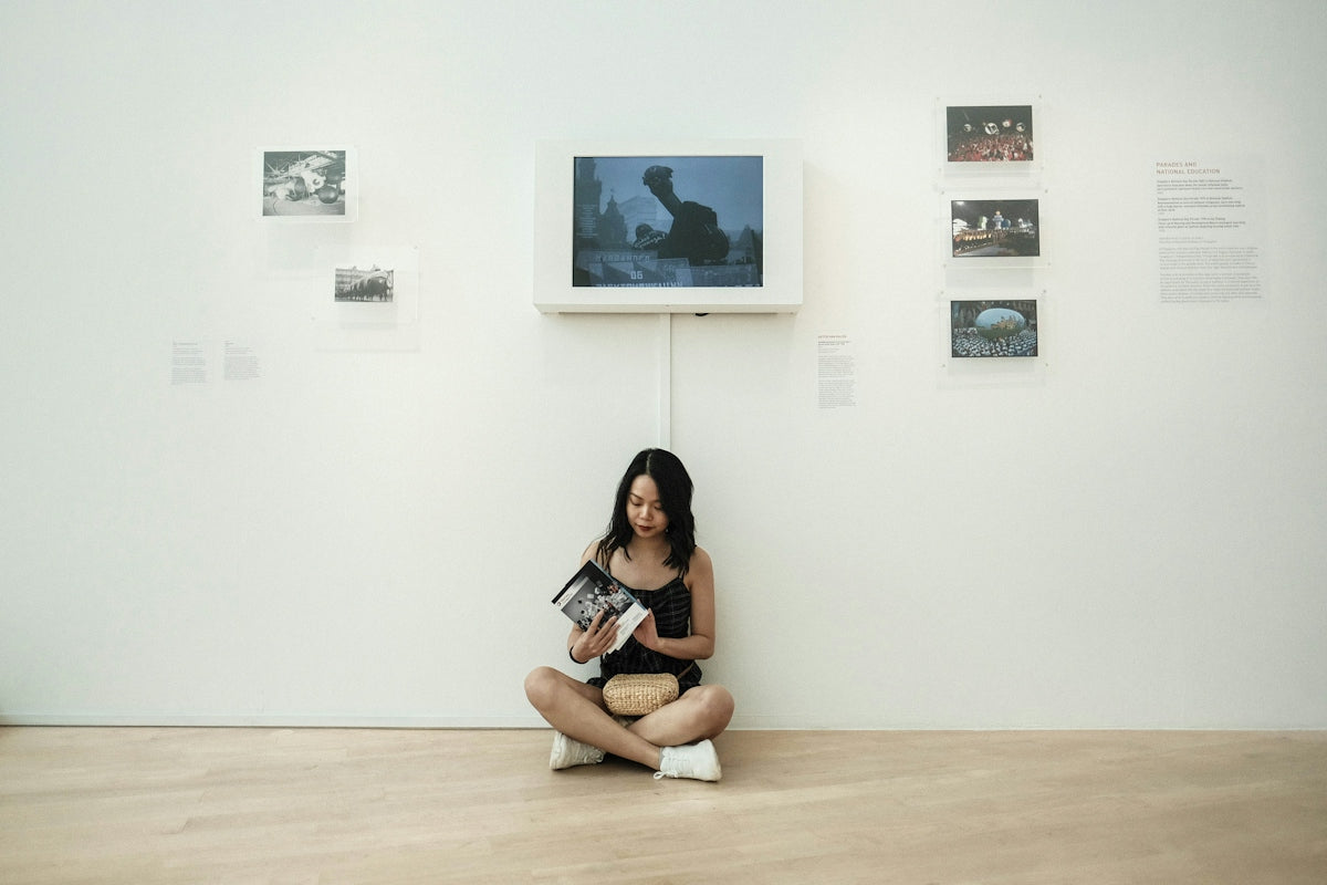 woman sitting near wall and monitor inside room
