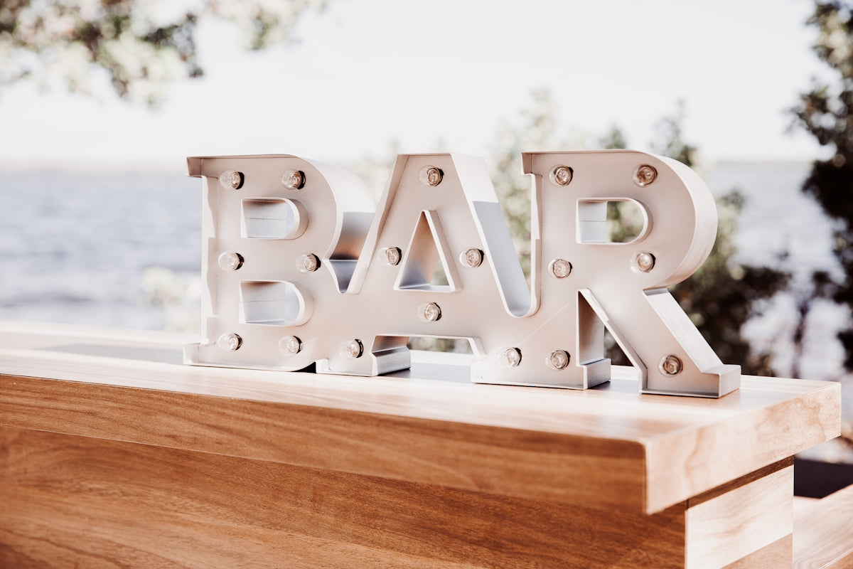 a bar sign sitting on top of a wooden table