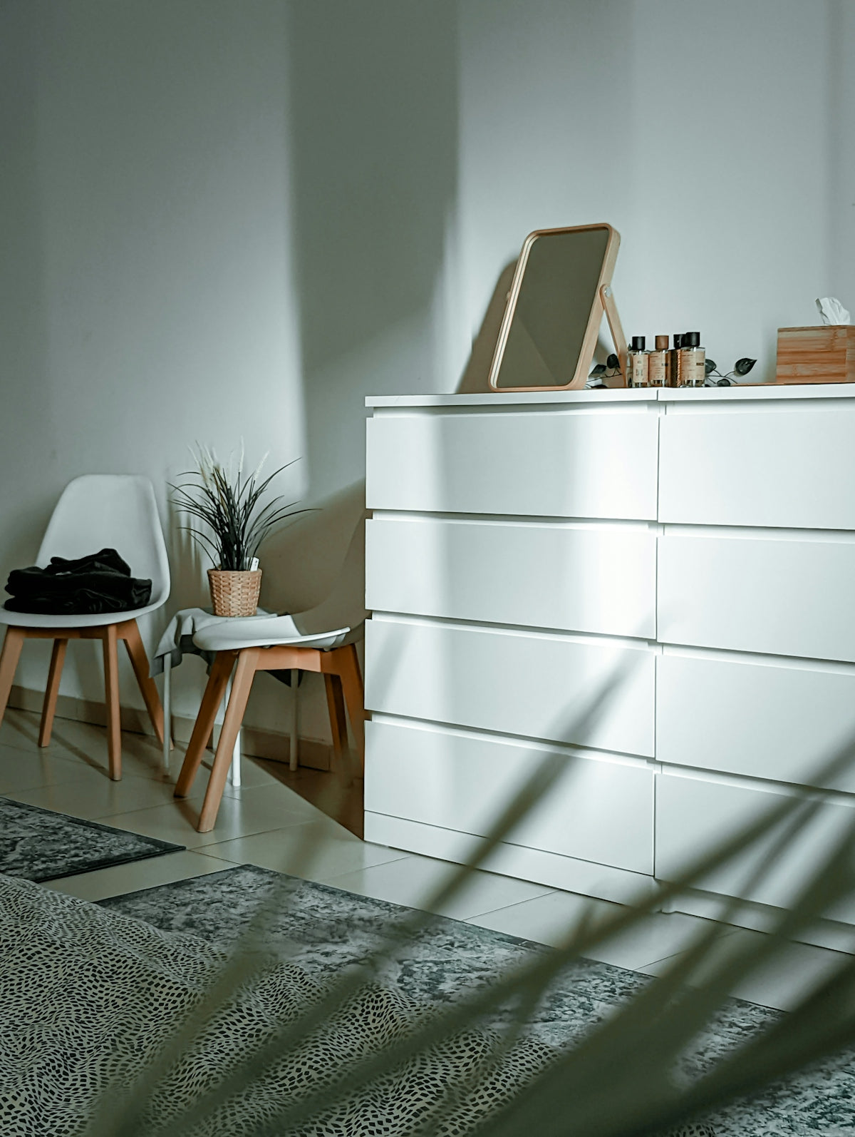a white cabinet with a chair and a plant on top