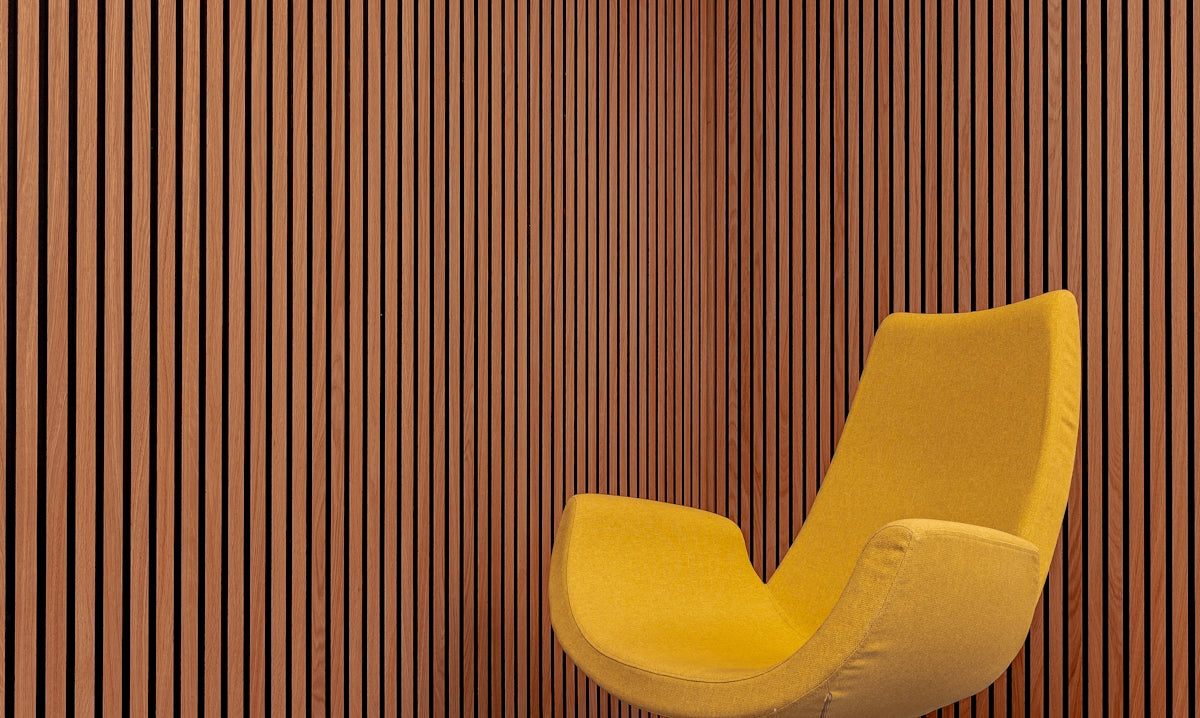 a yellow chair sitting in front of a wooden wall
