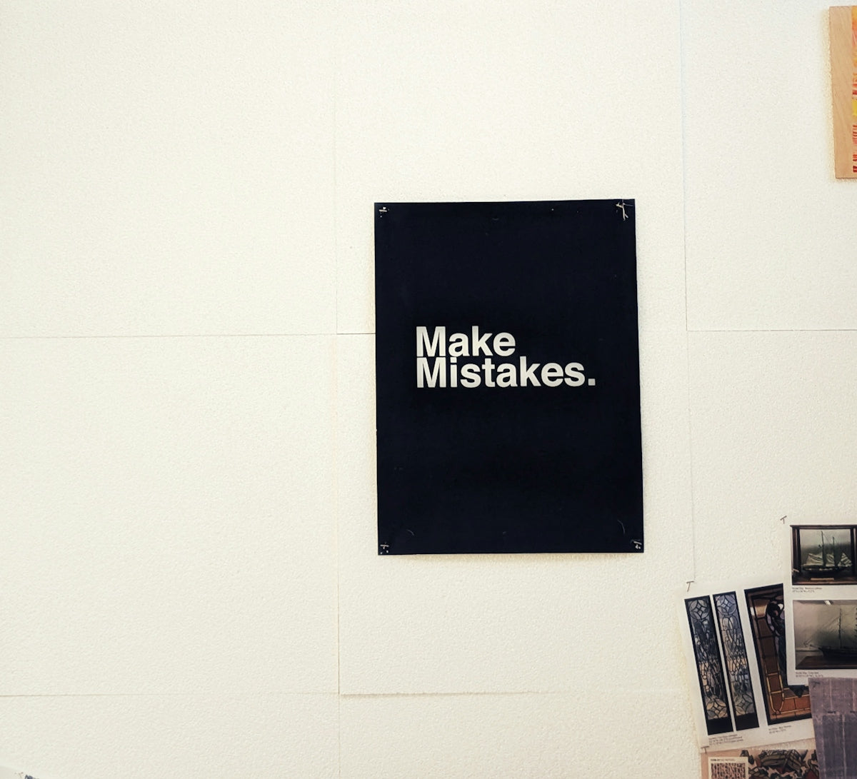 a black sign hanging on a white wall