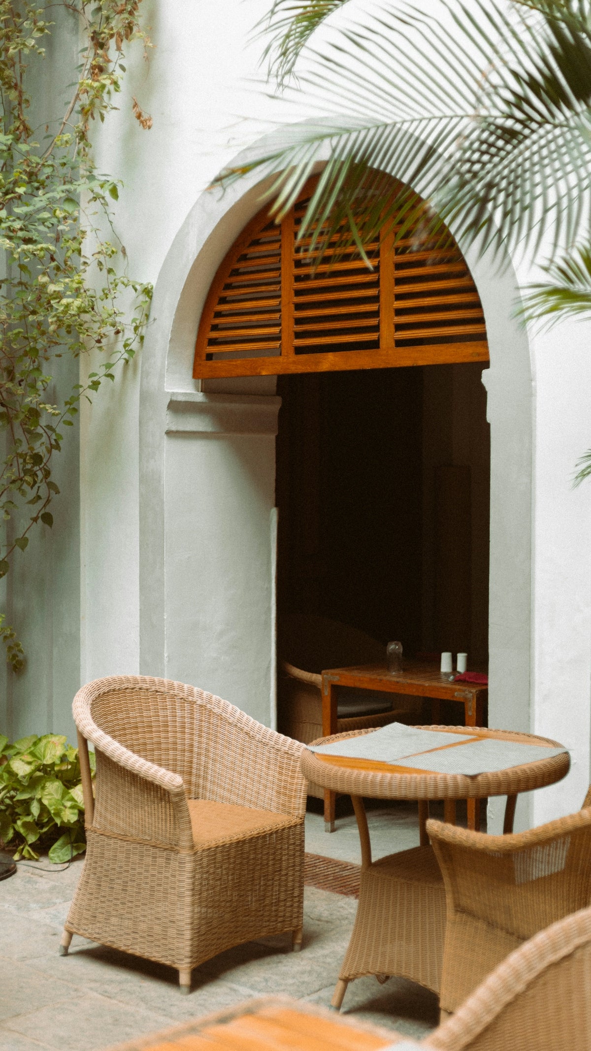 a patio with wicker chairs and a table