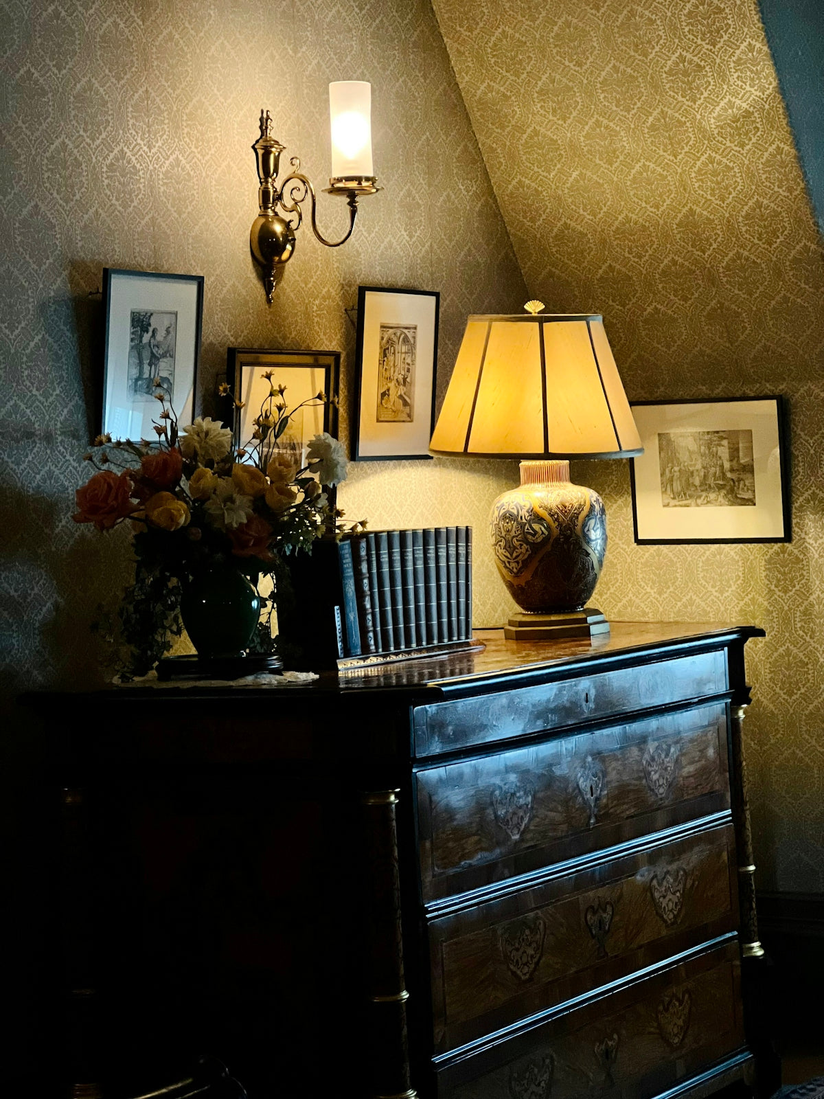 a dresser with a lamp and pictures on it