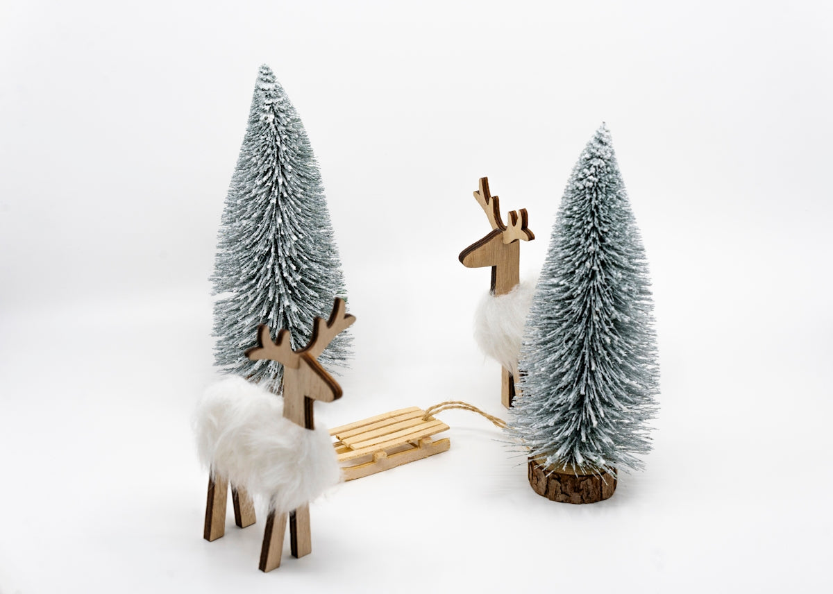 a couple of wooden reindeer standing next to a sleigh