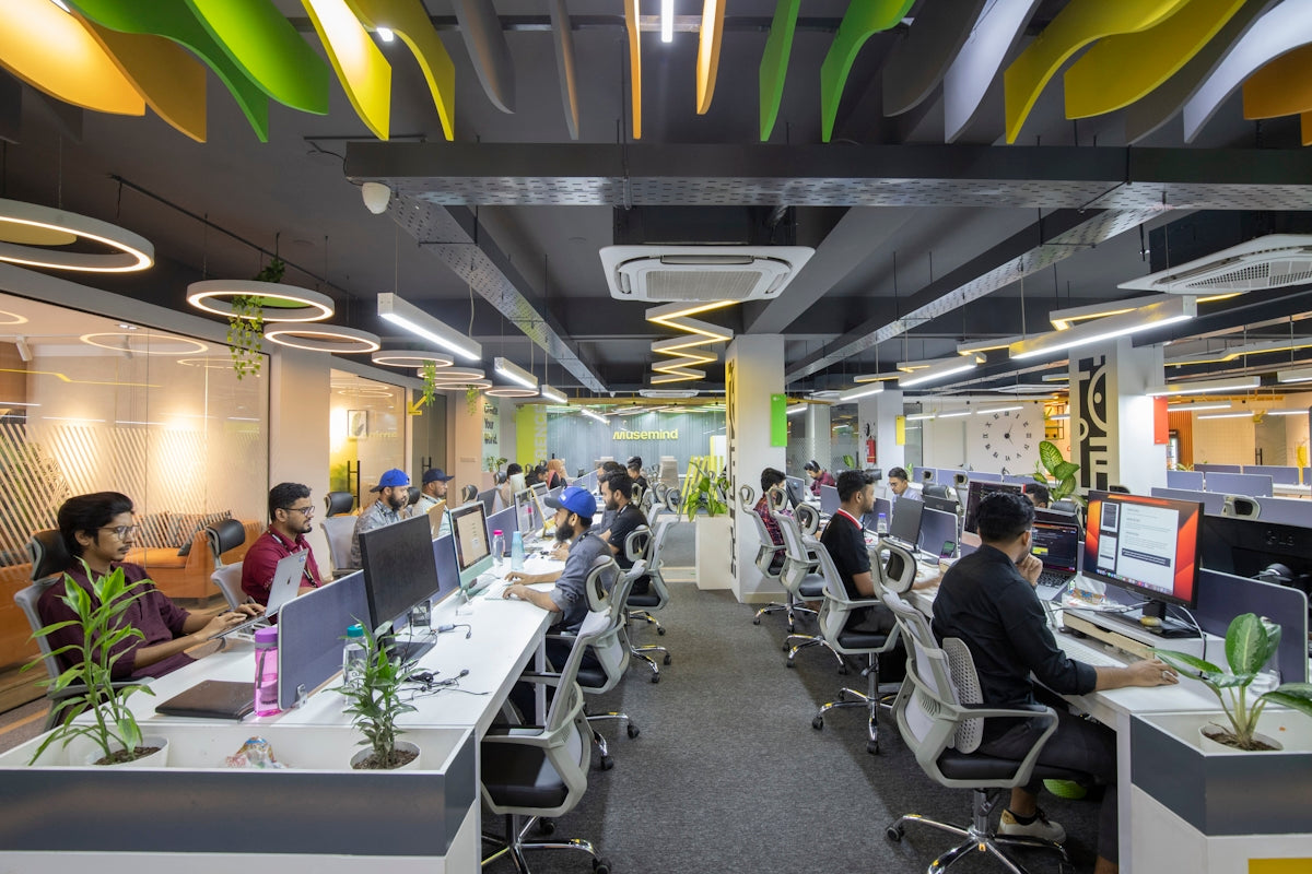 a group of people sitting at desks in an office