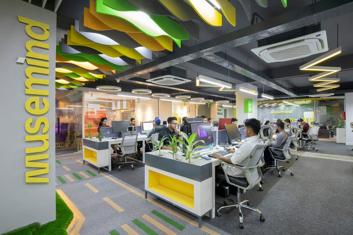 a group of people sitting at desks in an office