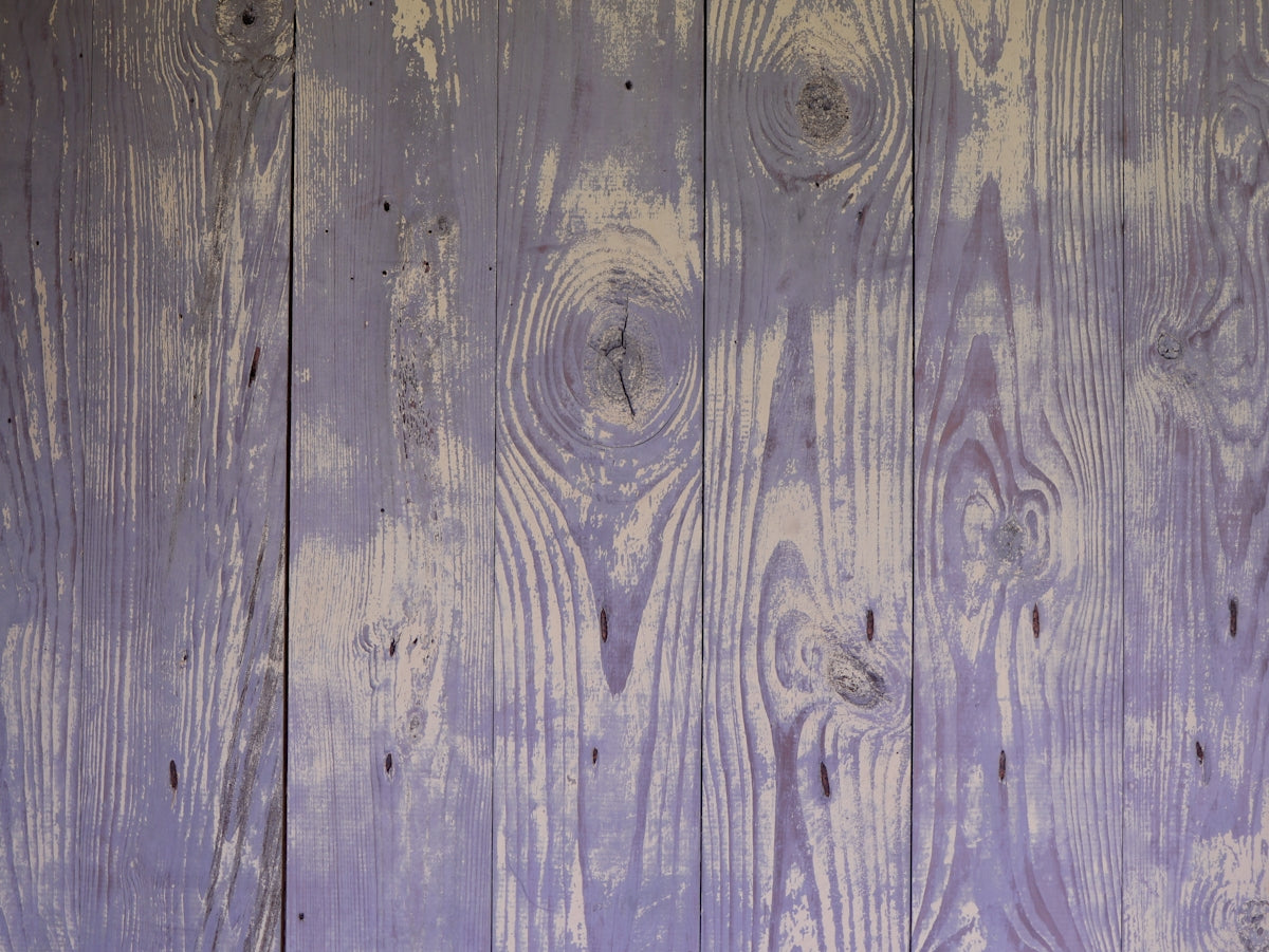 a close up of a wooden wall with purple paint