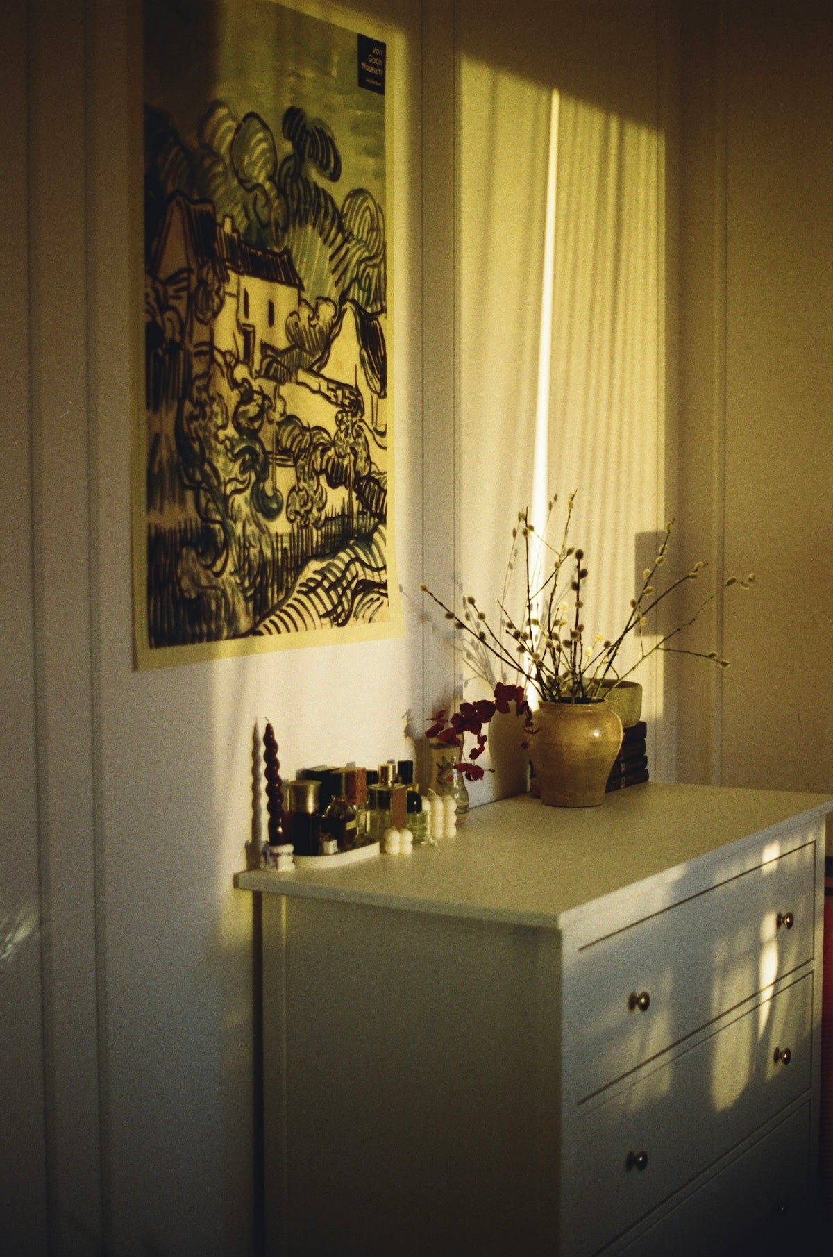 a room with a dresser and a painting on the wall