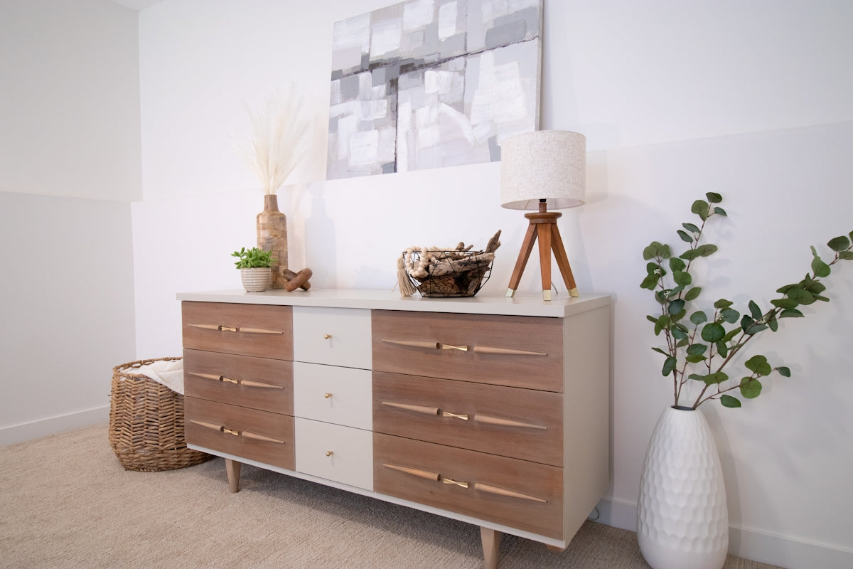 A white vase sitting on top of a wooden dresser