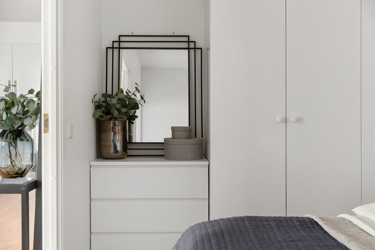 A bedroom with a bed, dresser and mirror