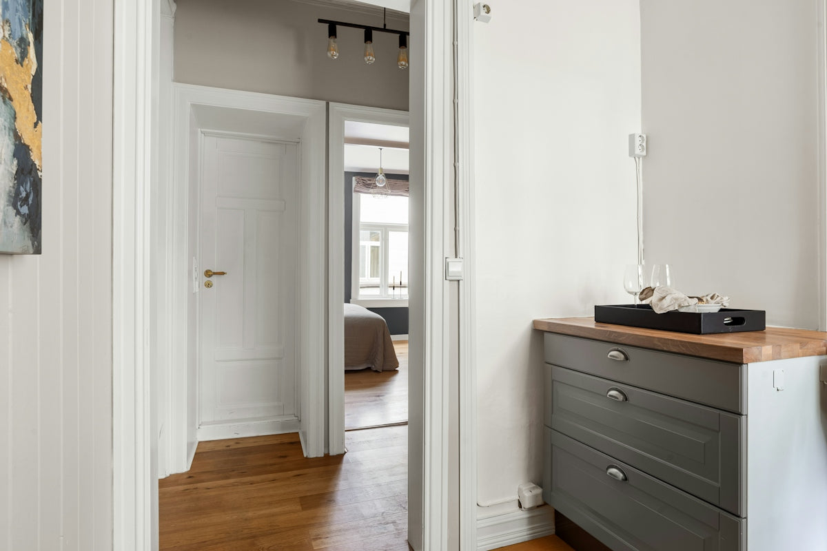 A room with a dresser and a painting on the wall