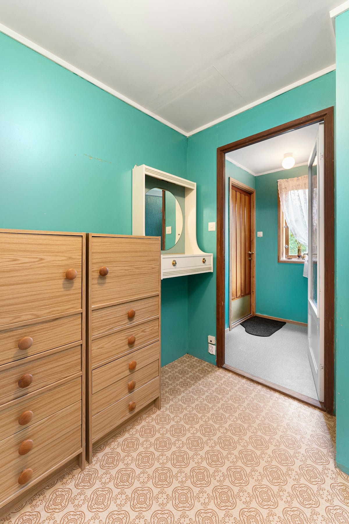 A bedroom with a dresser and a mirror