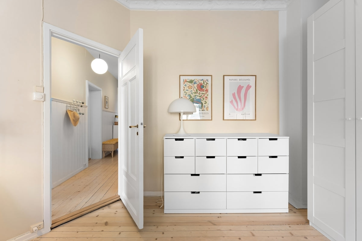 A room with a white dresser and a mirror