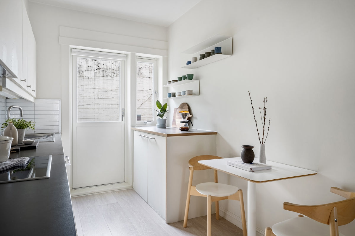 A small kitchen with a table and chairs