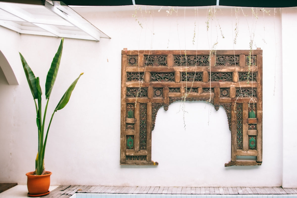 A pool with a fountain and a bamboo screen on the wall