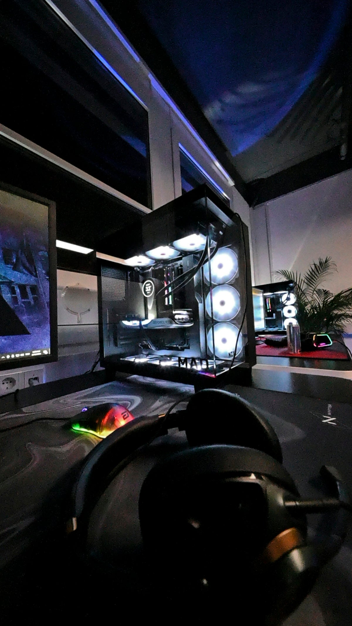 A gaming room with a large monitor and a mouse
