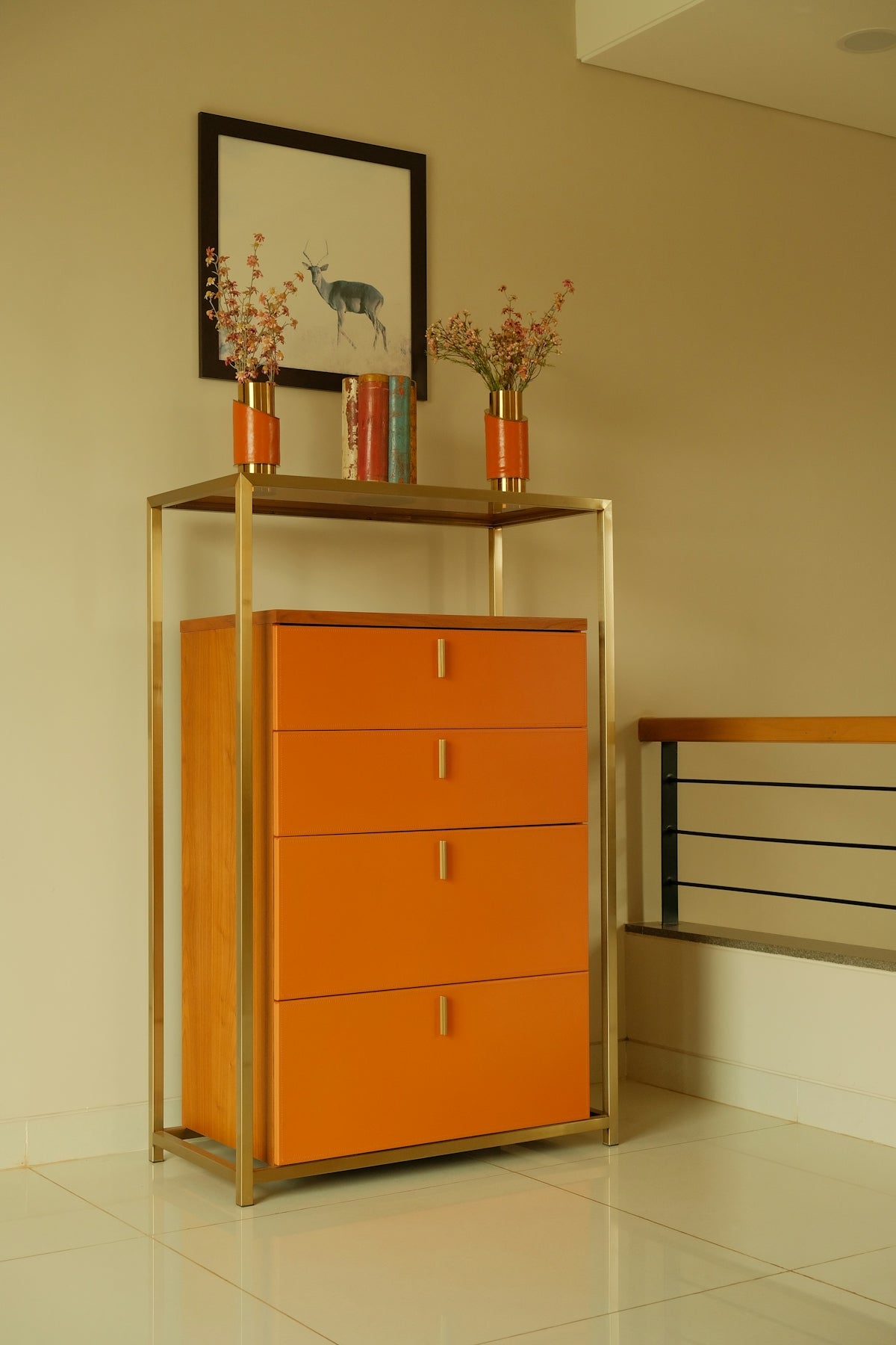 An orange dresser in a room with a picture on the wall