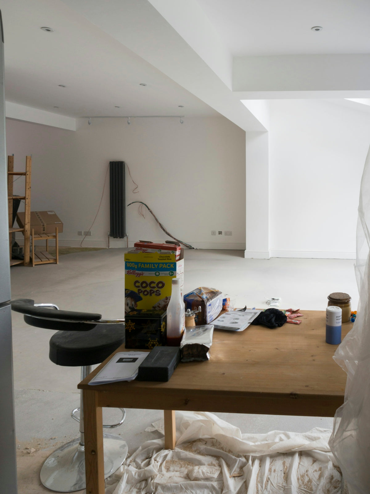 A room that has a table and a refrigerator in it