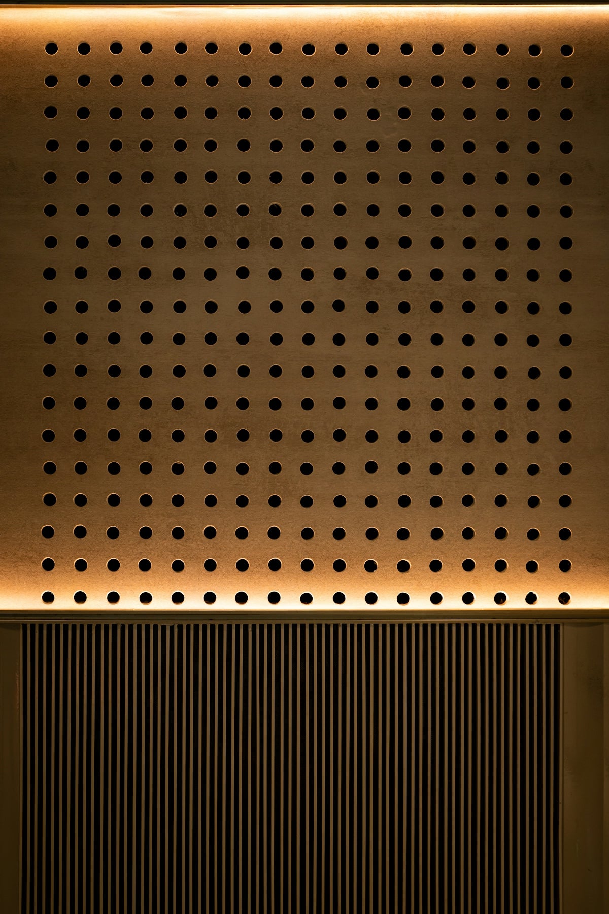 A wooden wall with many circular holes.