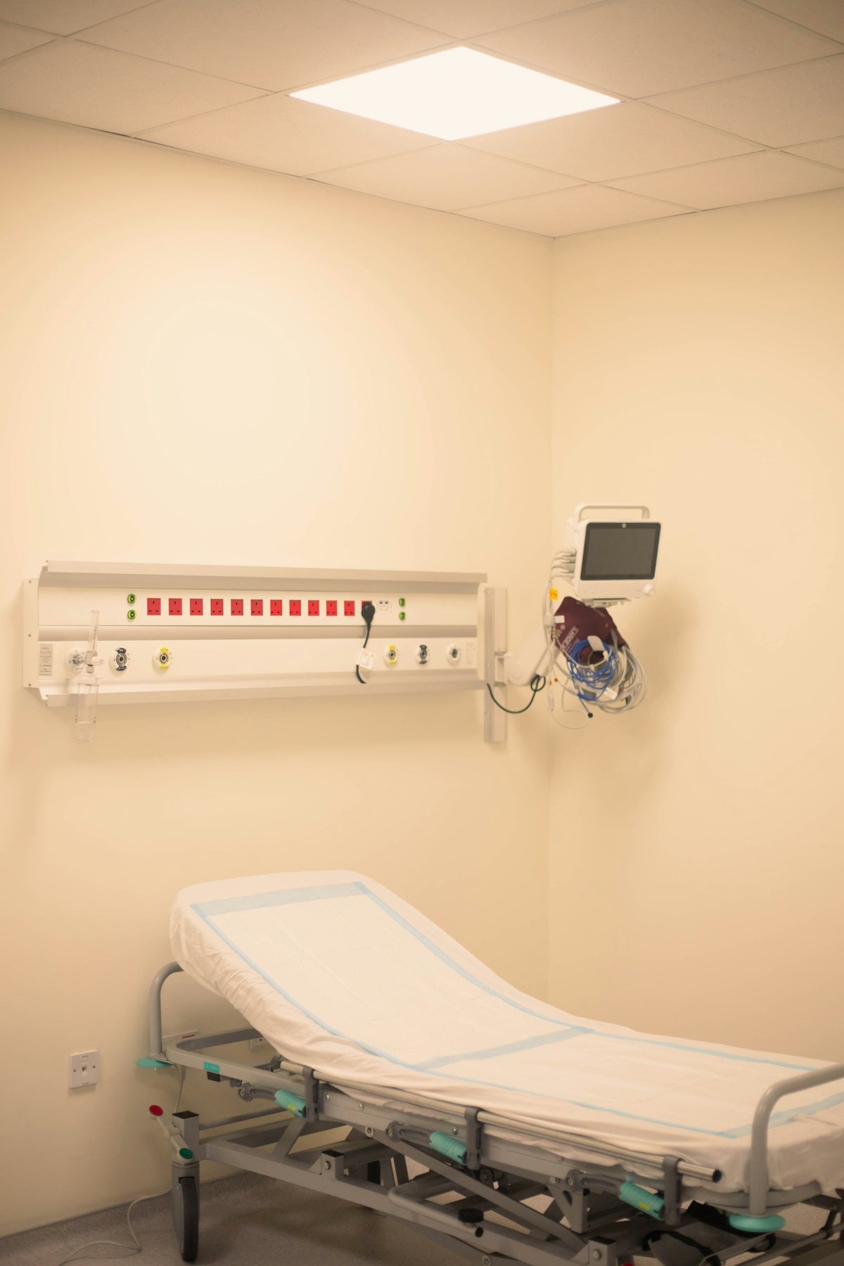 Hospital room with bed and medical equipment.