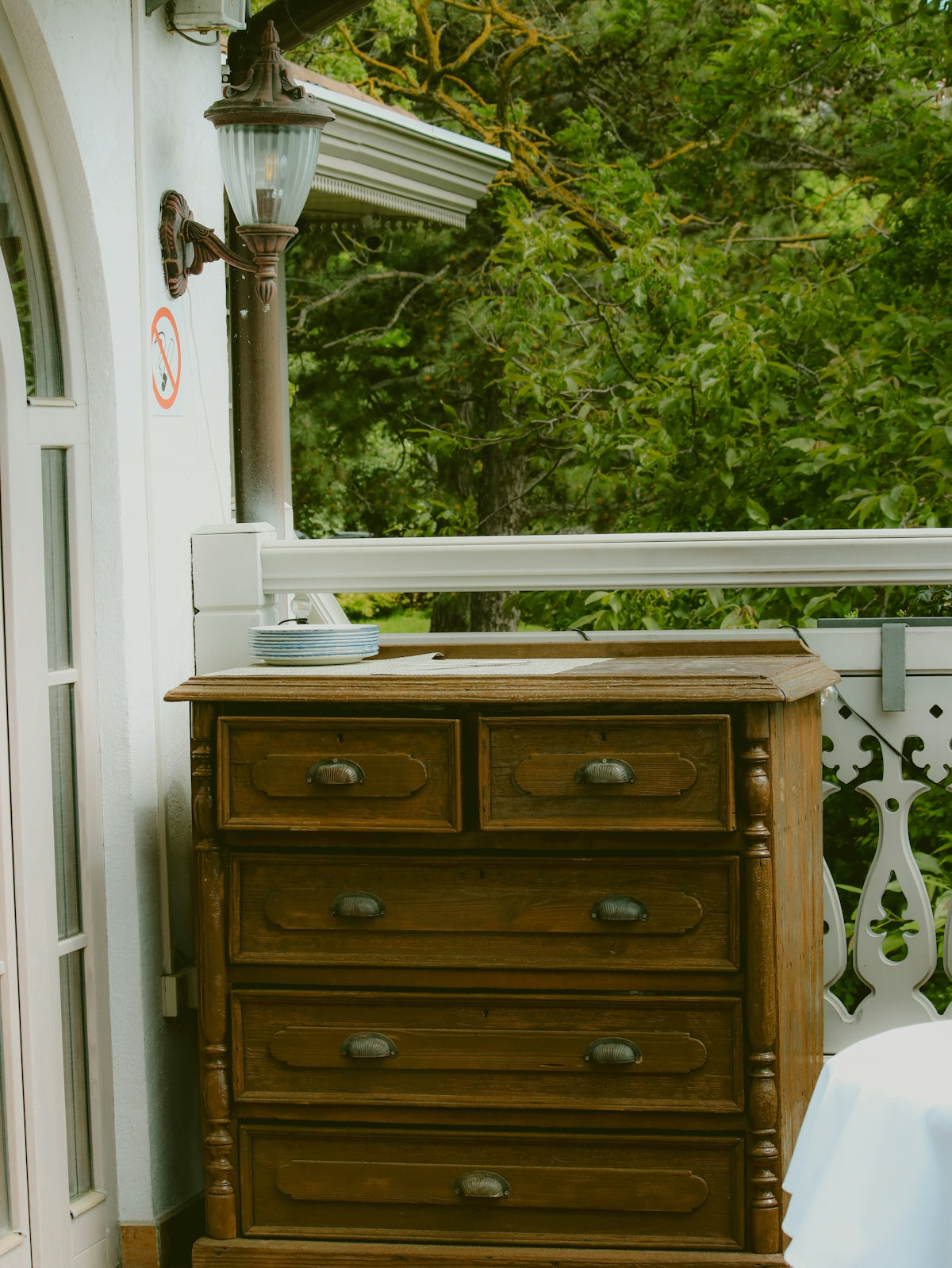 A wooden dresser sits on an outdoor balcony.