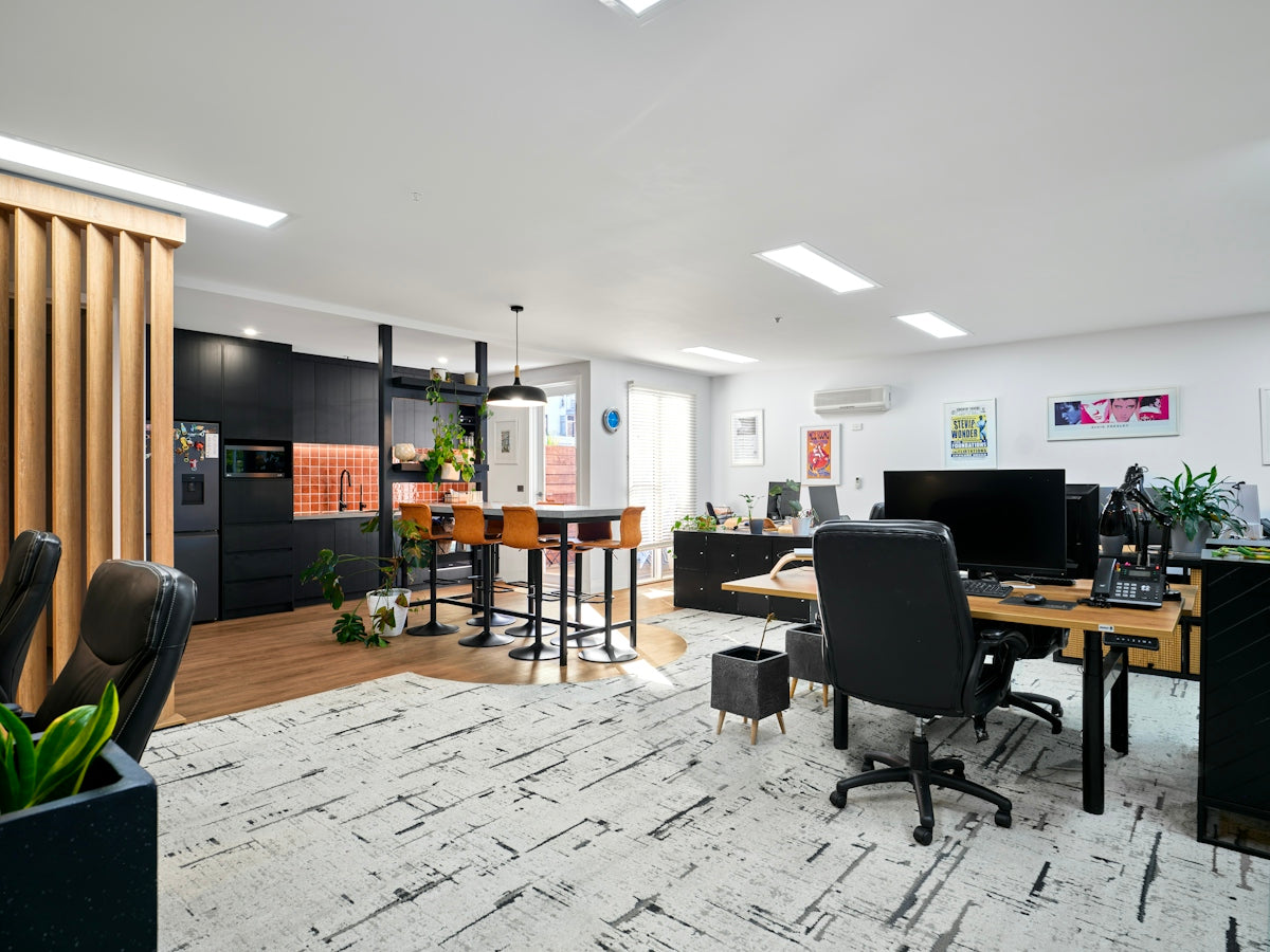 A modern, stylish office with workspace and lounge areas.