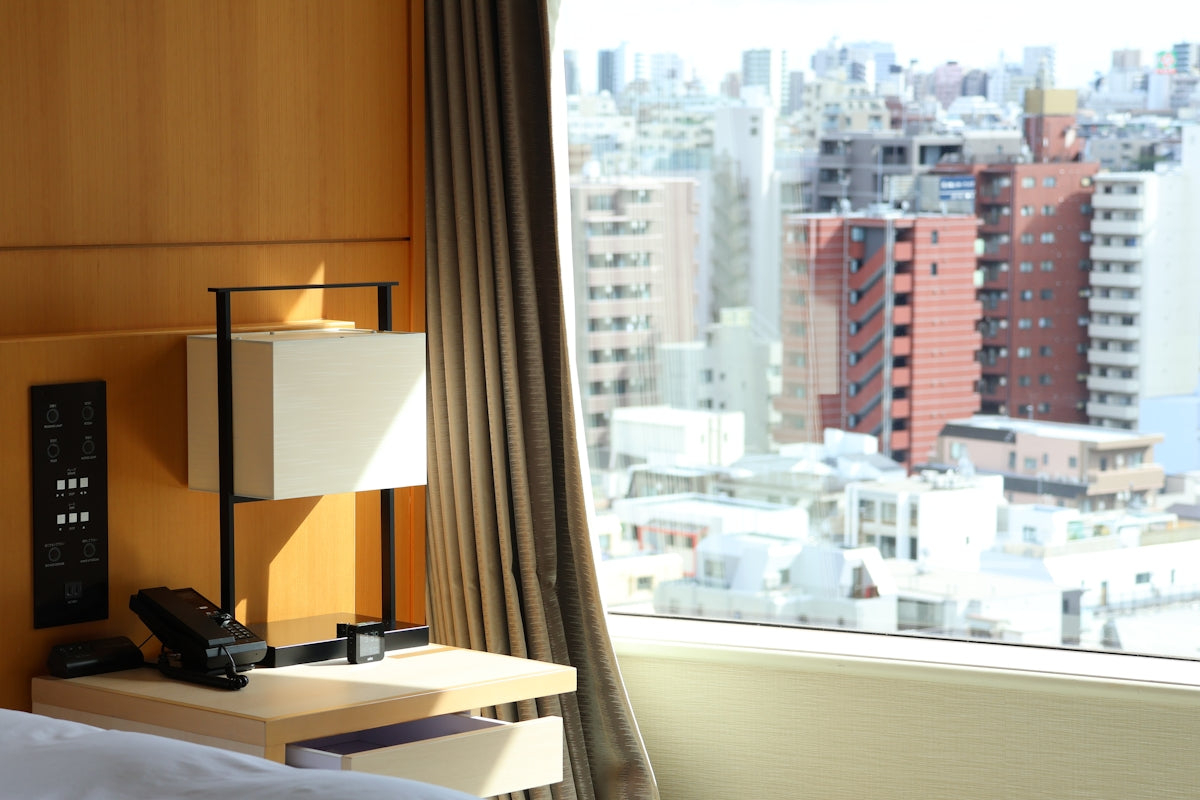 A hotel room overlooks a busy cityscape.