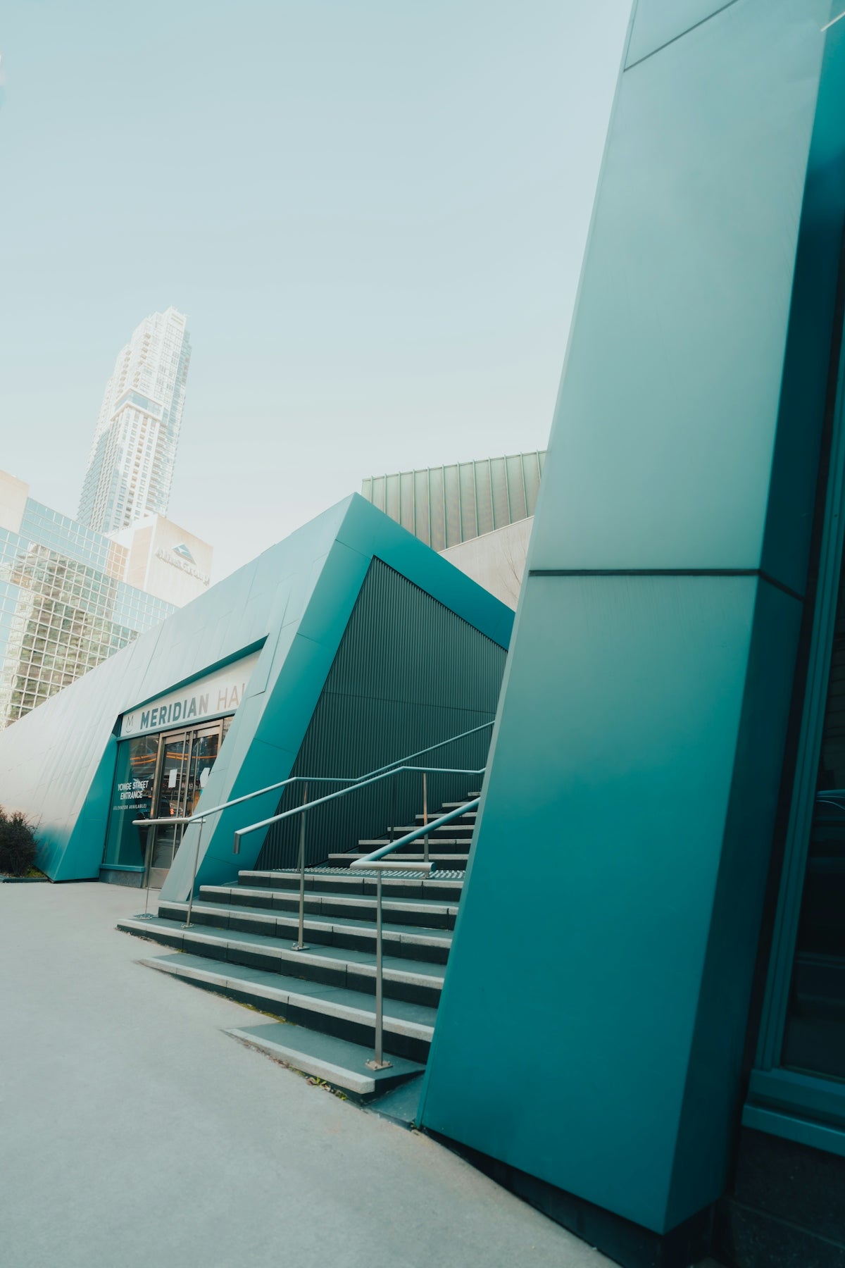 Modern building with geometric teal accents and stairs.