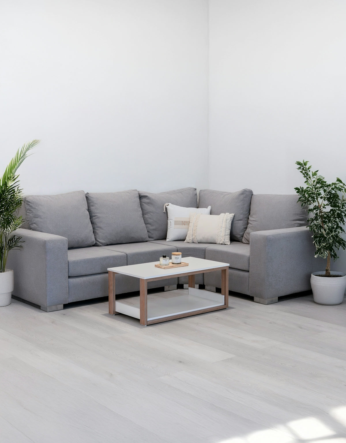 Gray sectional sofa with a coffee table and plants.