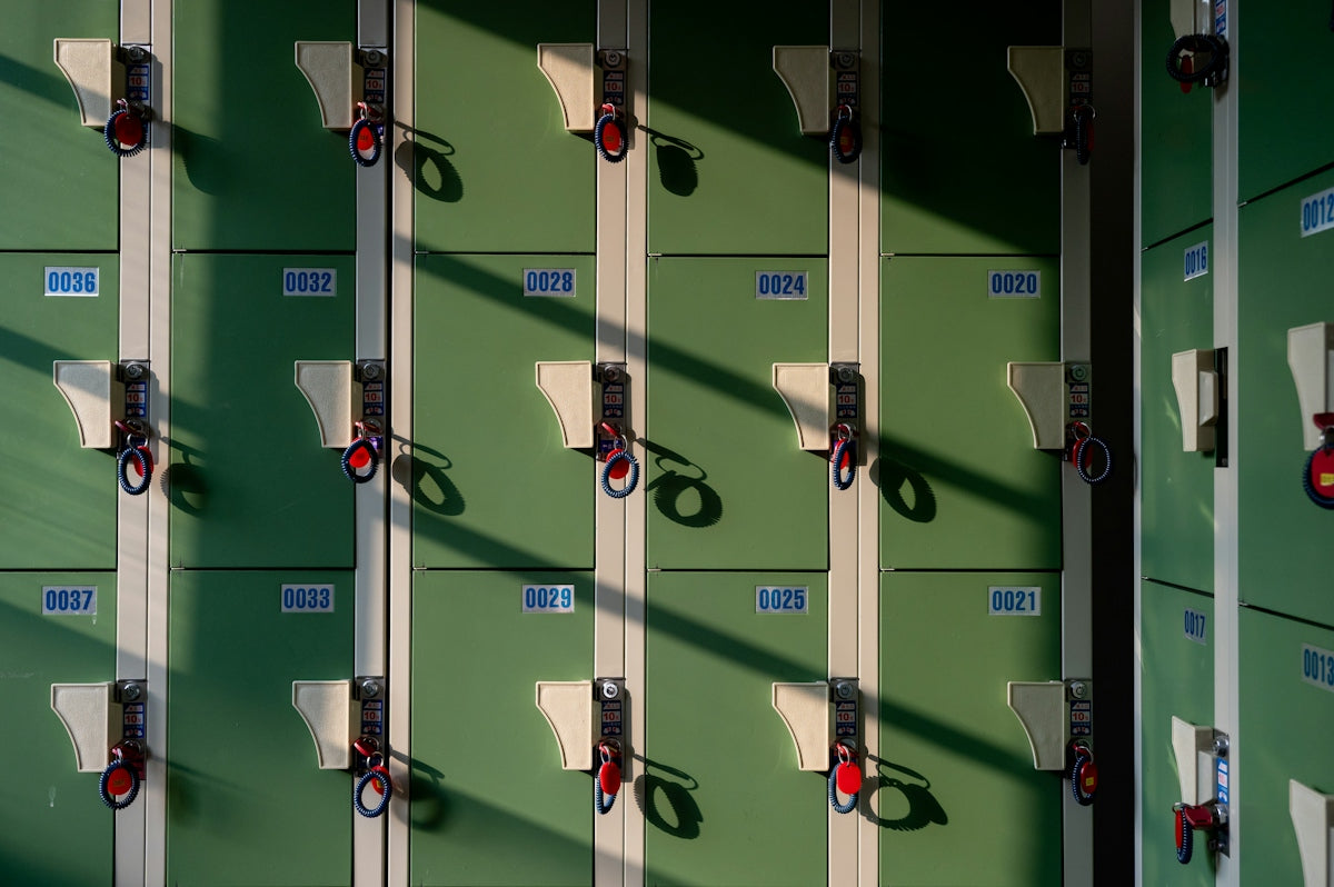 Green lockers with red locks and sunlight shadows