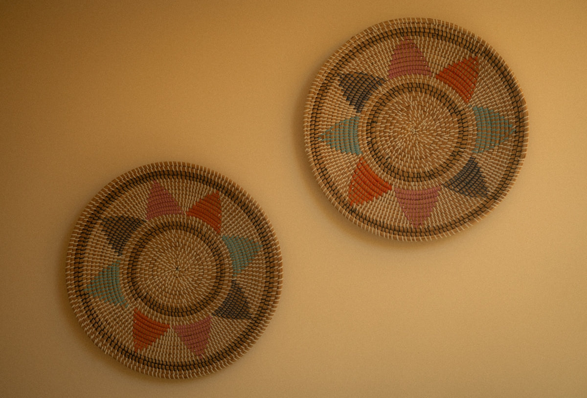 Two woven decorative plates with colorful patterns