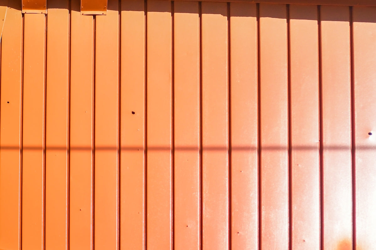 Orange corrugated metal wall with shadows