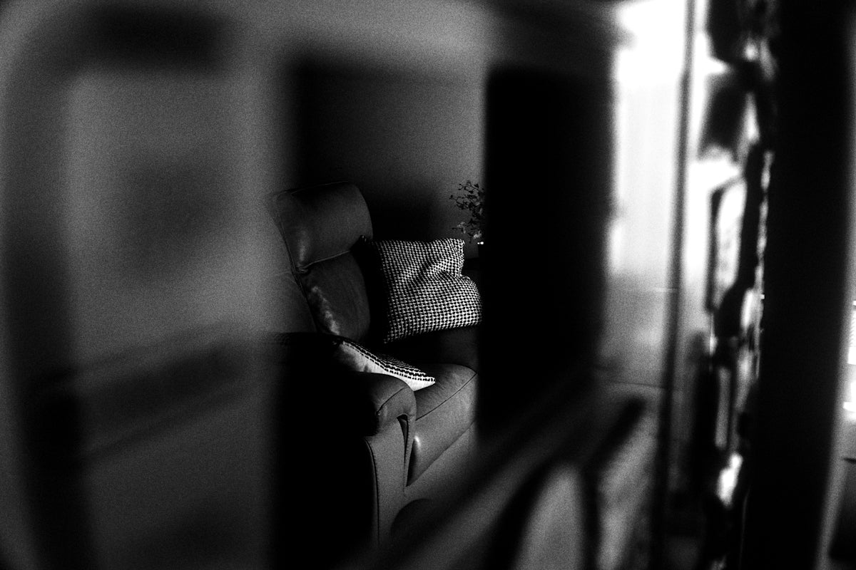 A dimly lit room with a sofa and couch.