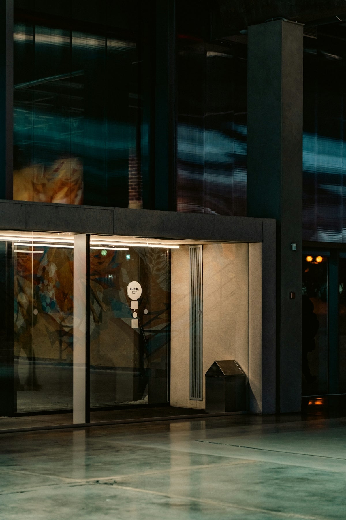 Modern building entrance with glass doors and reflections