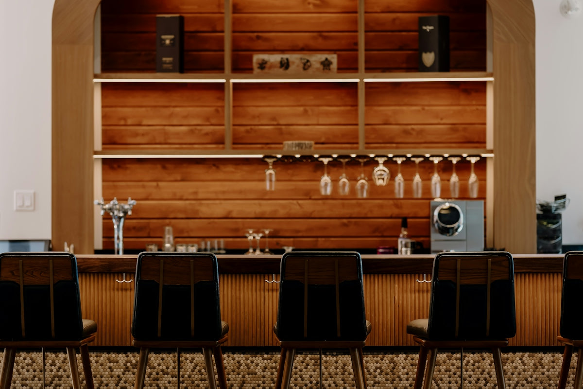 Modern bar with wooden accents and black stools