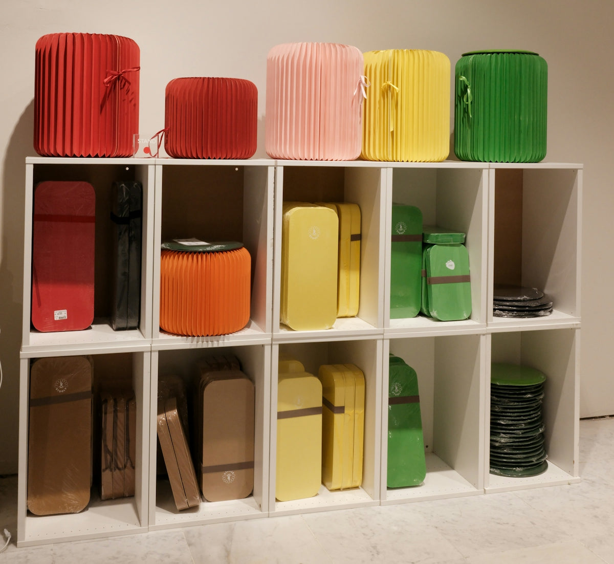 Colorful storage units and items on white shelves