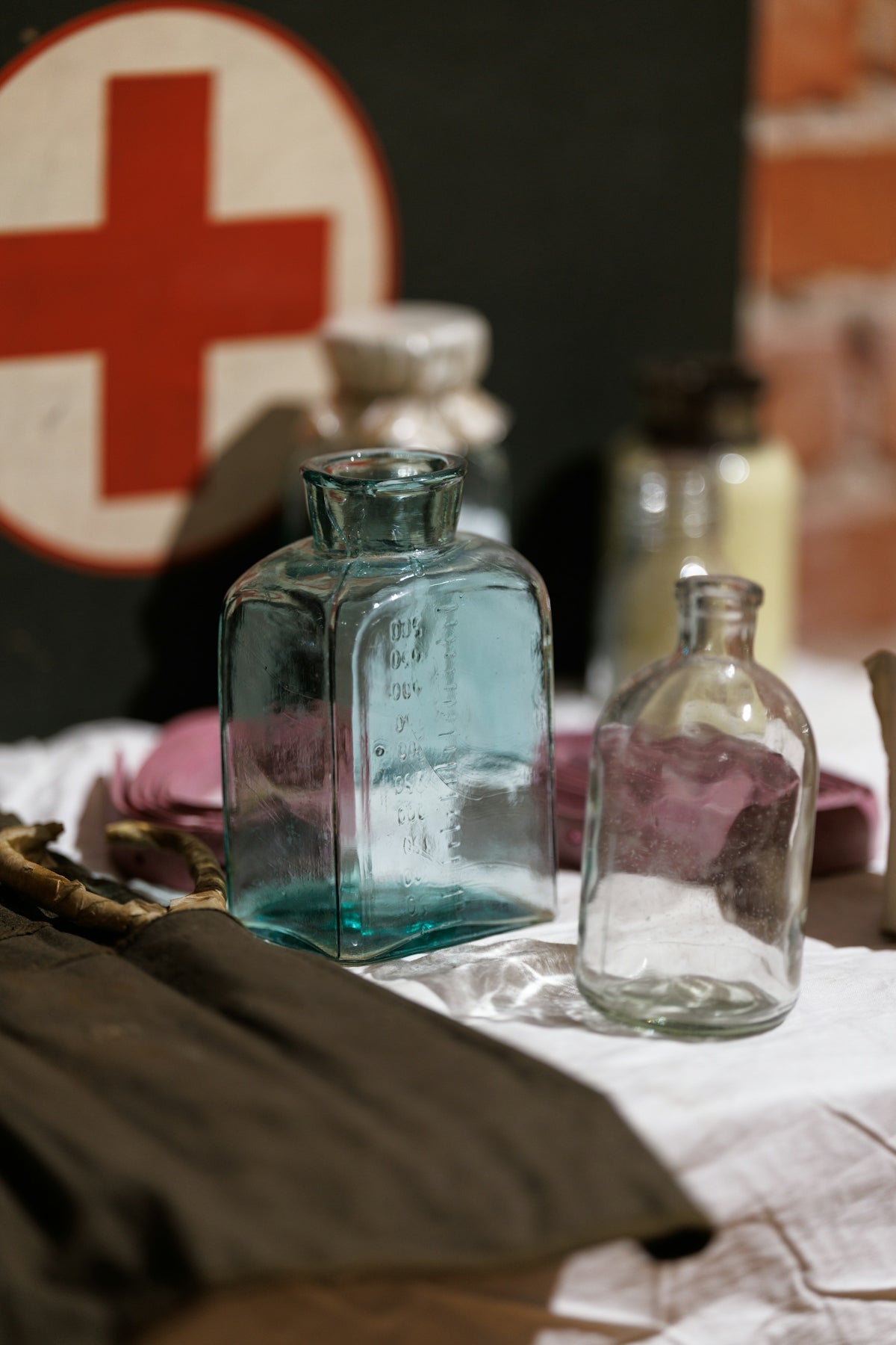 Antique medical bottles and red cross symbol.