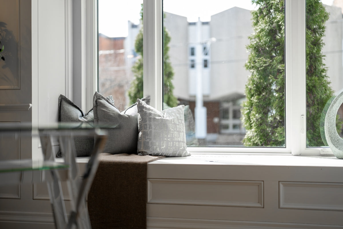 Two decorative pillows on a window seat.