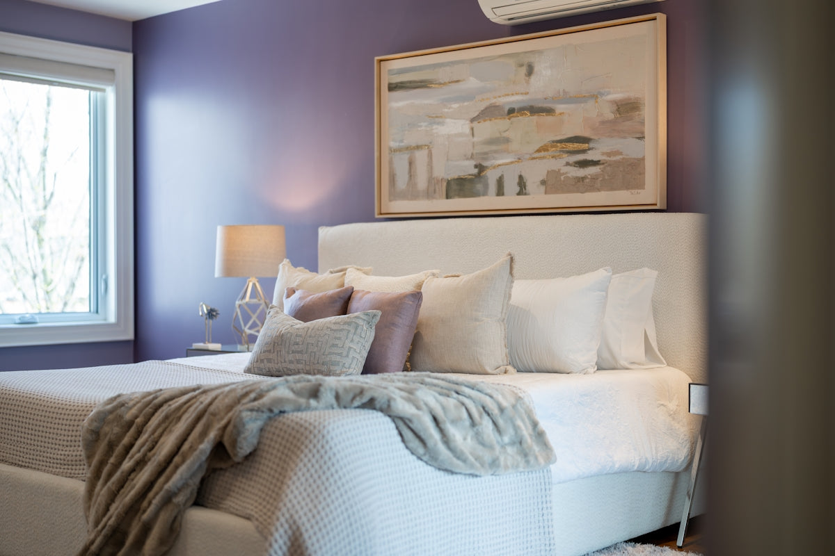 A cozy bedroom with a white bed and purple walls.