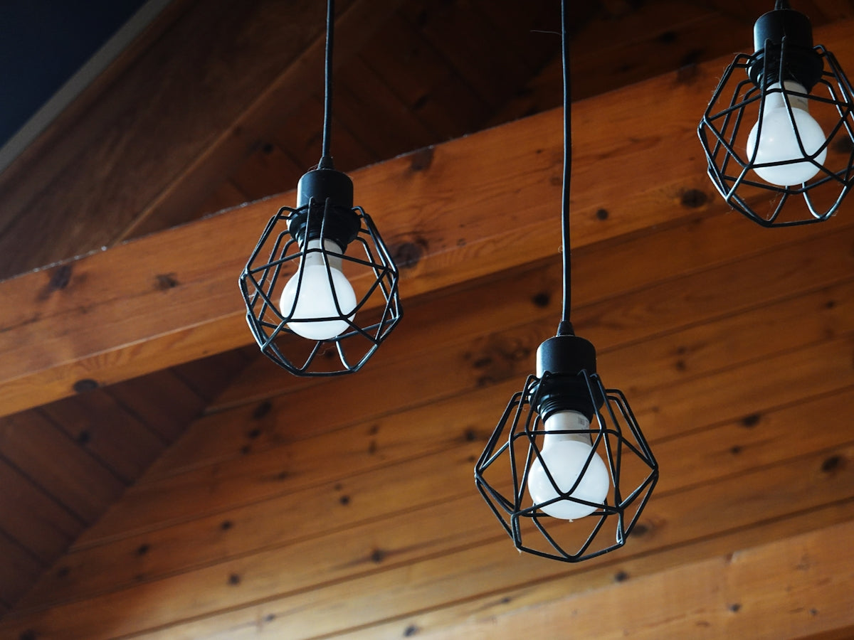 Three industrial-style pendant lights hanging indoors.