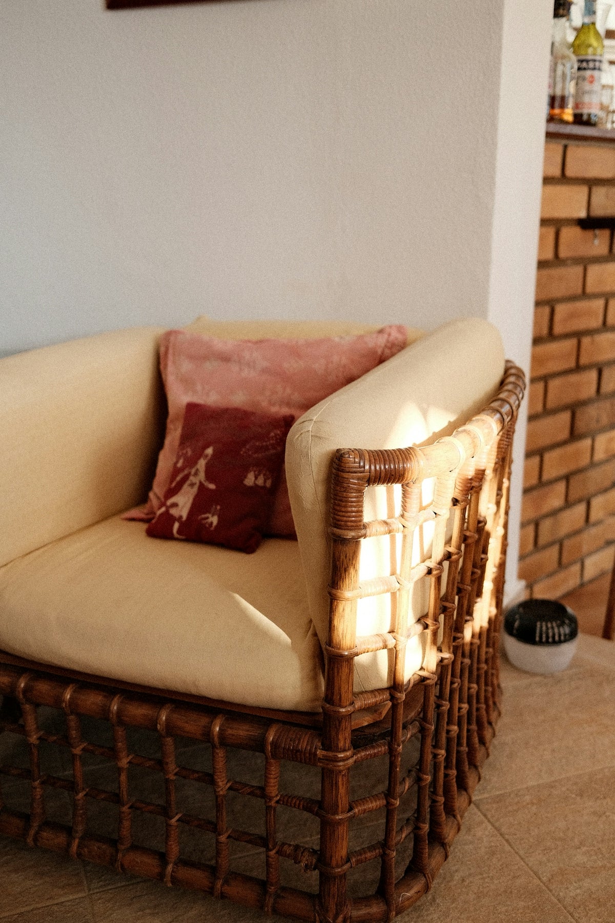 A wicker chair with decorative pillows indoors.
