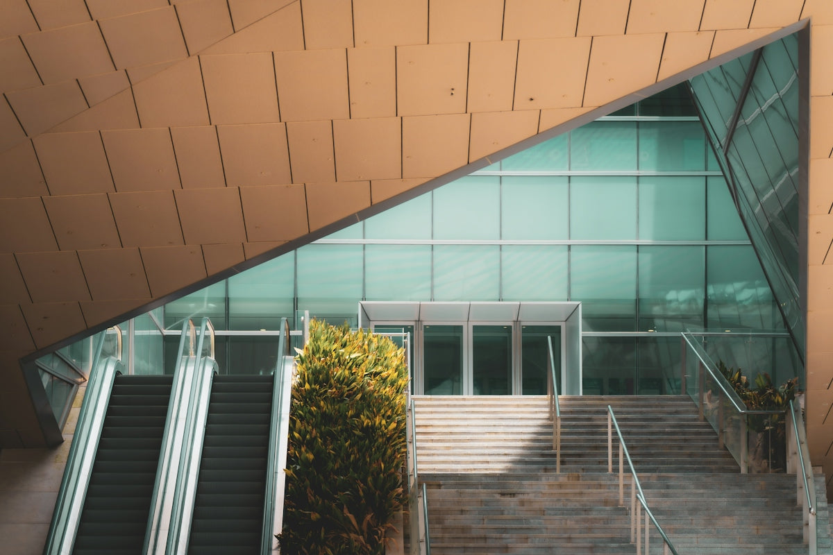 Modern building with glass entrance, stairs, and escalators.