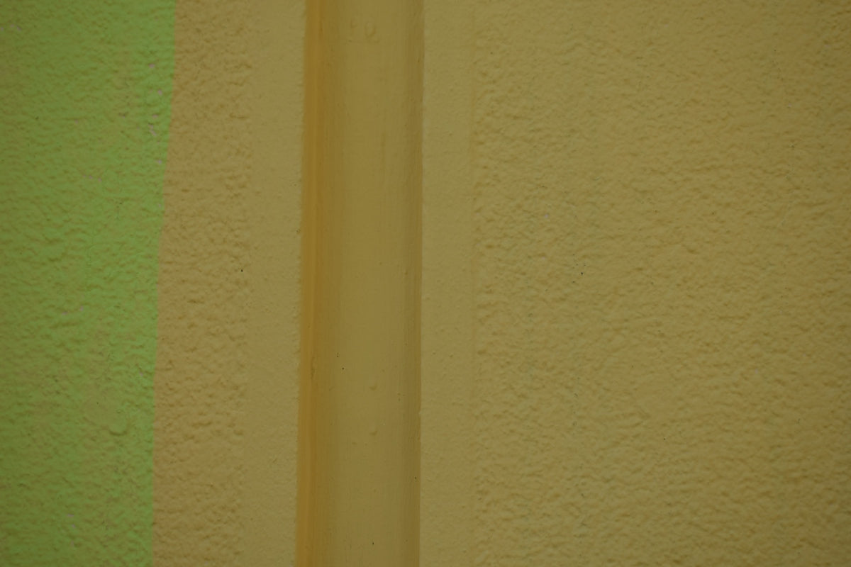 Green and beige textured wall with a vertical dividing line