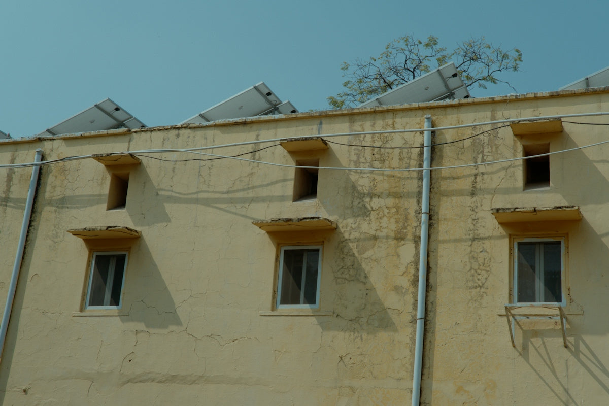 Beige building with windows and solar panels on roof.
