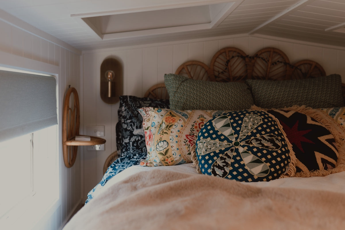 Cozy bedroom with decorative pillows and a wicker headboard.