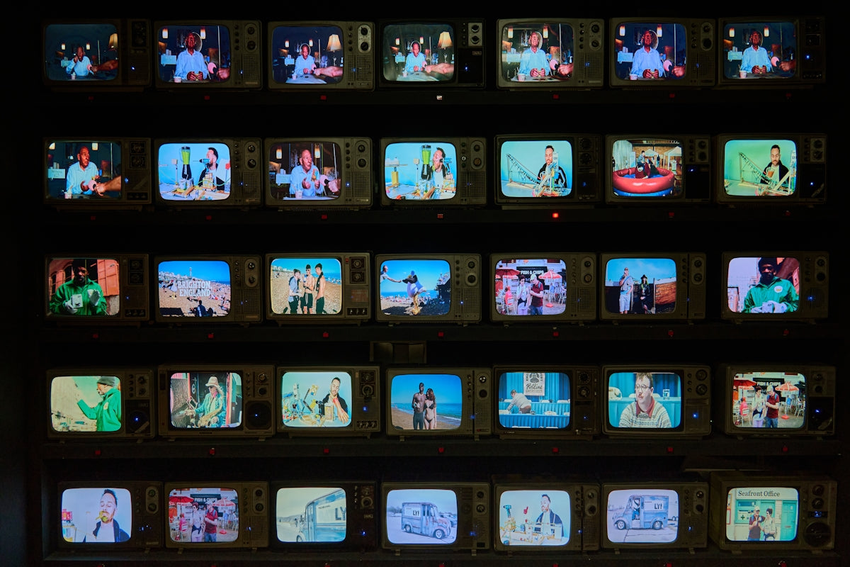 A wall of multiple small televisions displaying different scenes.