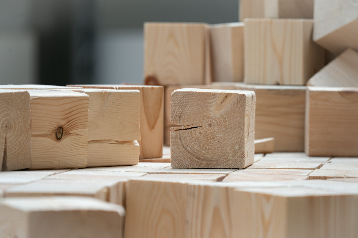 Many light wooden blocks are scattered and stacked.